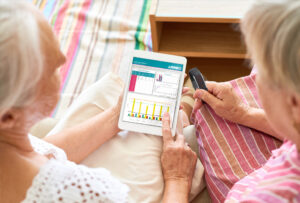 Image of two senior women looking at a dashboard on a tablet