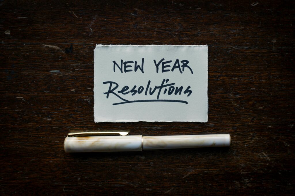 Image of a note with New year resolution written on it, with a pen