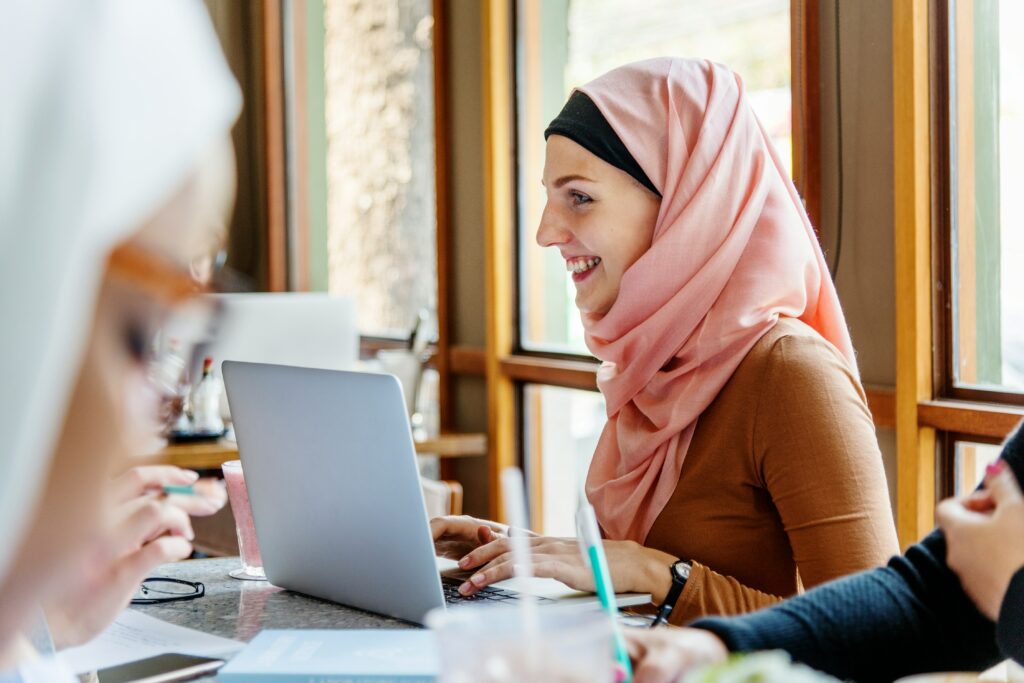 Image of a young woman in headscarf on a computer